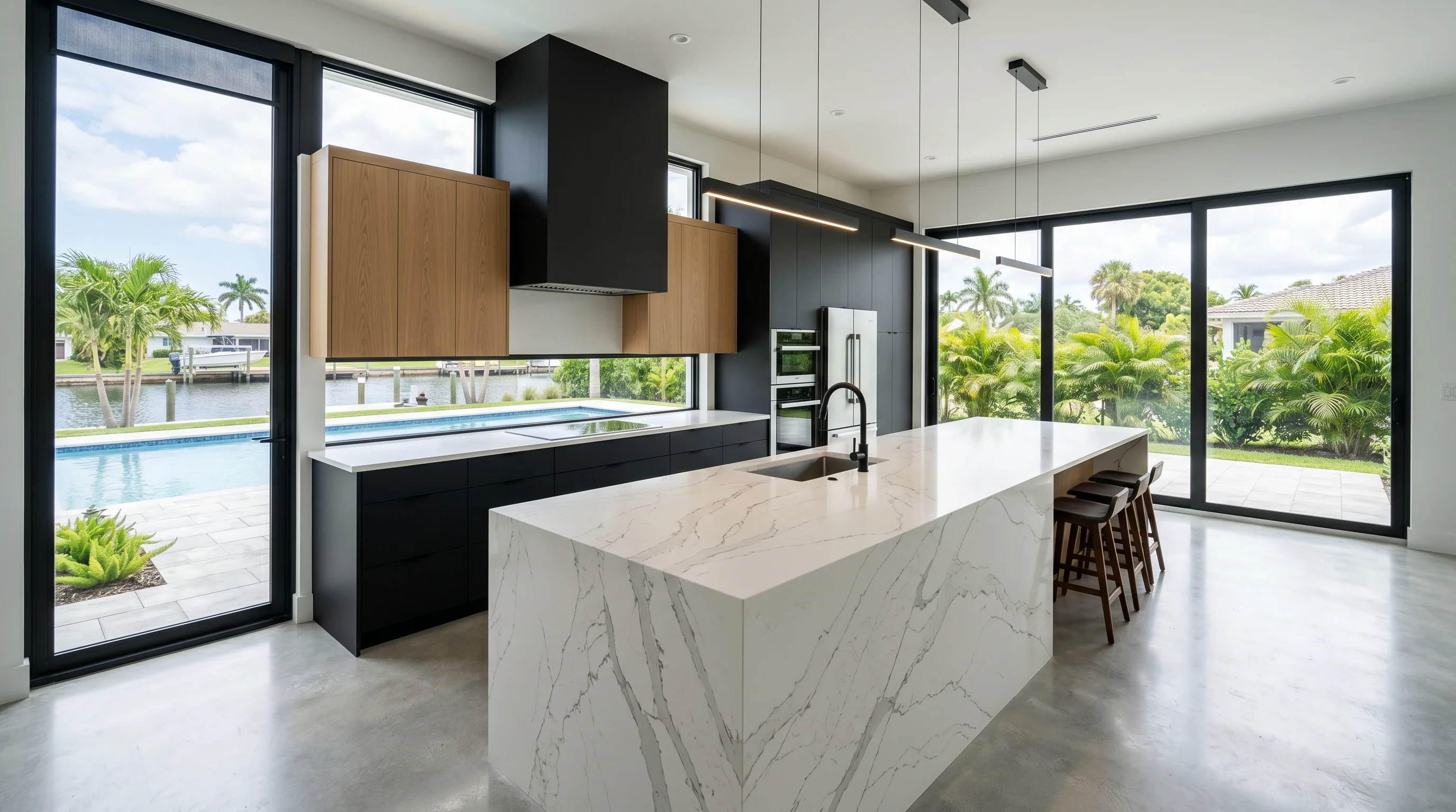 Ultra-wide Westlake kitchen with marble waterfall island and pool deck view