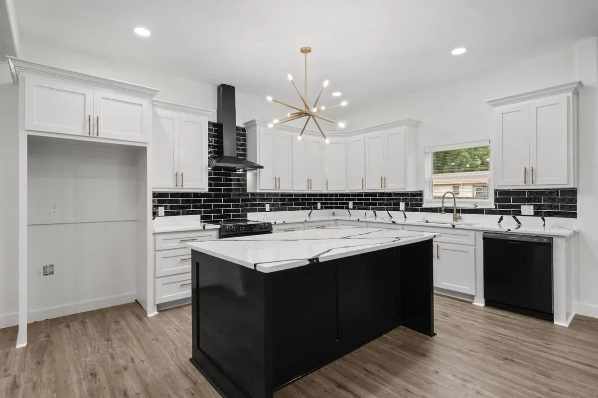 White shaker kitchen cabinets with black island and quartz countertops — kitchen remodeling near Jupiter, FL