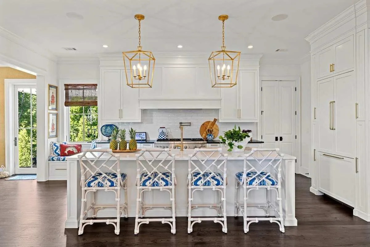 White custom kitchen cabinets with gold lantern pendant lights and marble island — kitchen remodeling in Jupiter, FL